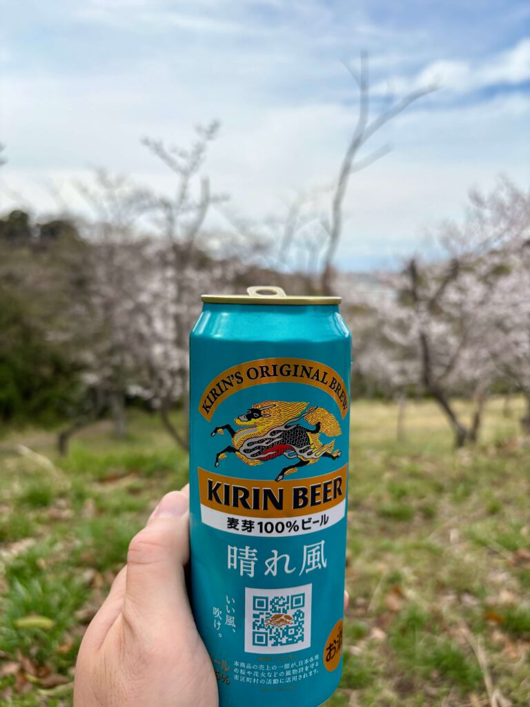 Myself enjoying Kirin Harekaze during ohanami, with cherry blossoms in the background.