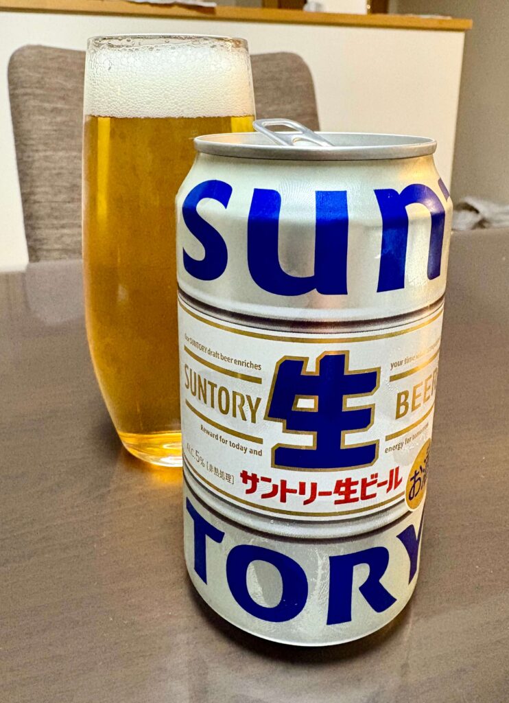 A glass of freshly poured Suntory Draft Beer, next to the can.