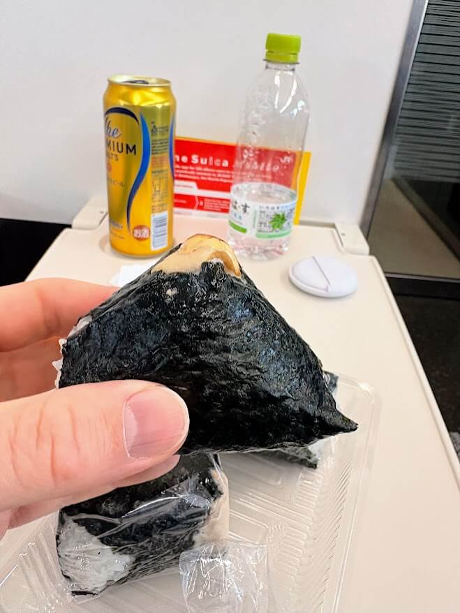 Me eating onigiri and having a beer on Azusa limited express train