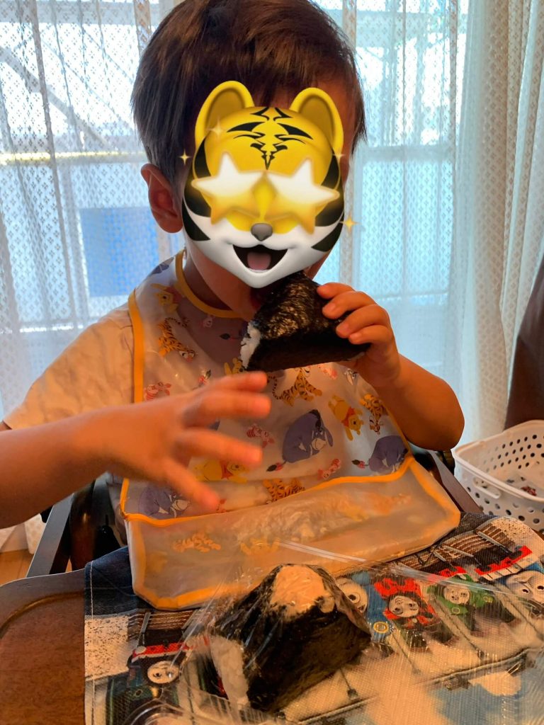 My son eating fresh tuna and mayo onigiri